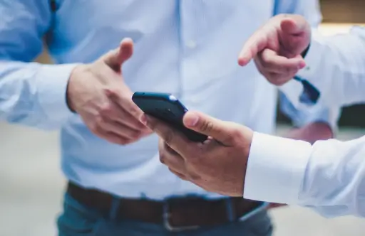 Image of a man showing someone something on his phone