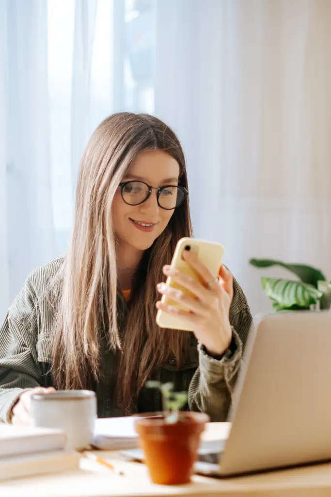 Image of woman looking at cell phone at workstation