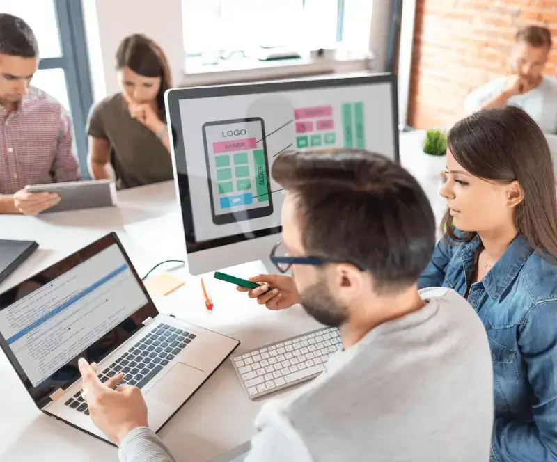 Image of 5 people sitting at a table working collaboratively